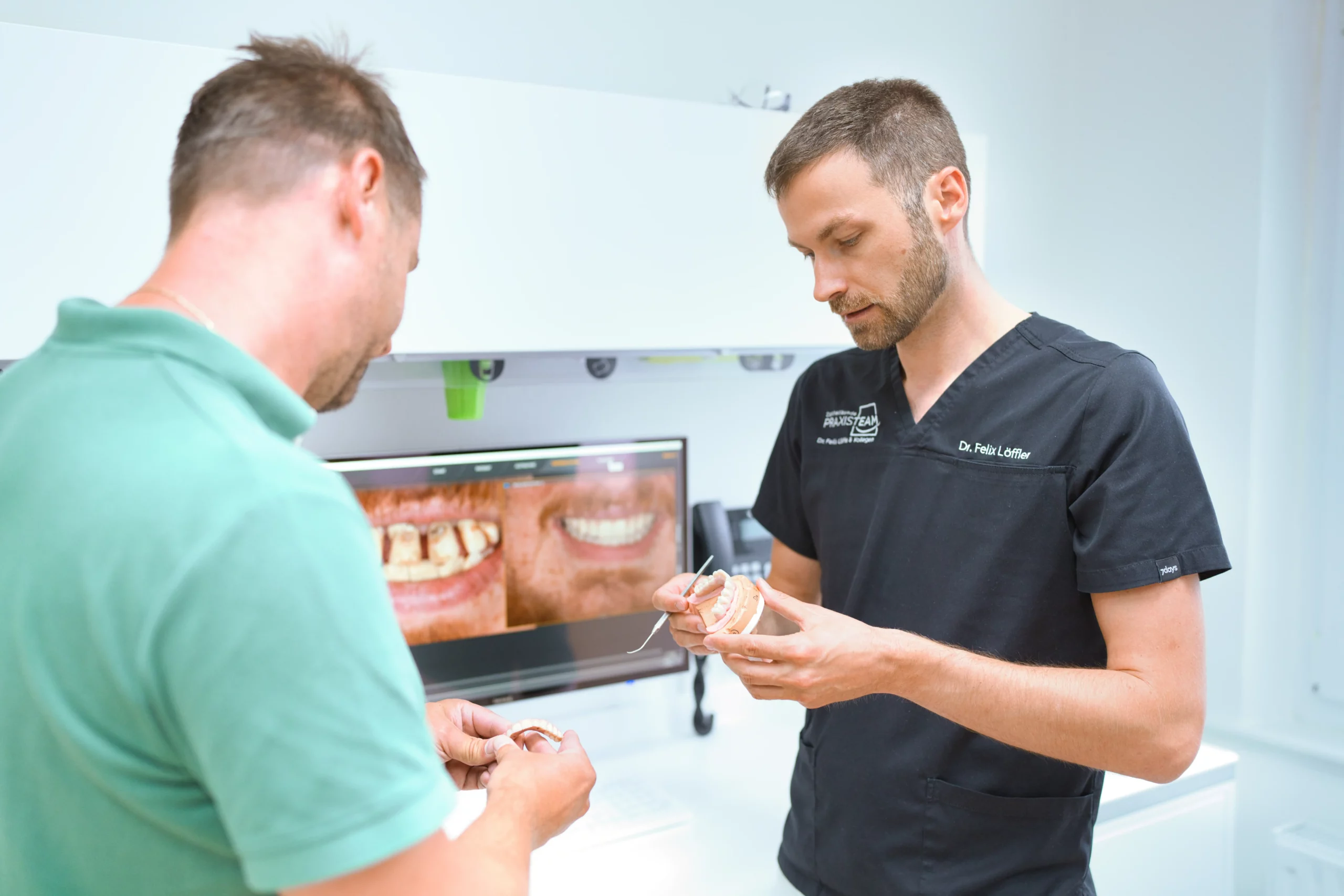 Zertifiziertes Implant Center of Excellence Dr. Felix Löffler und ein Zahntechniker im Meisterlabor zu einer Implantationsbesprechung